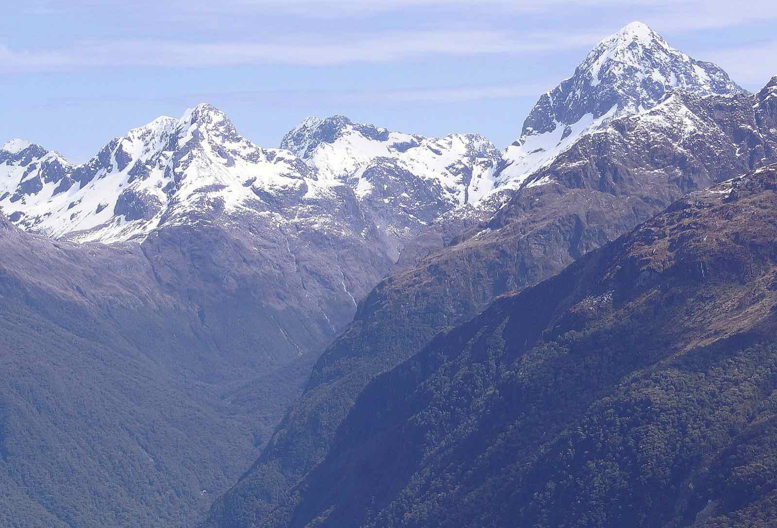 Snow-capped peaks above a deep valley under a blue sky