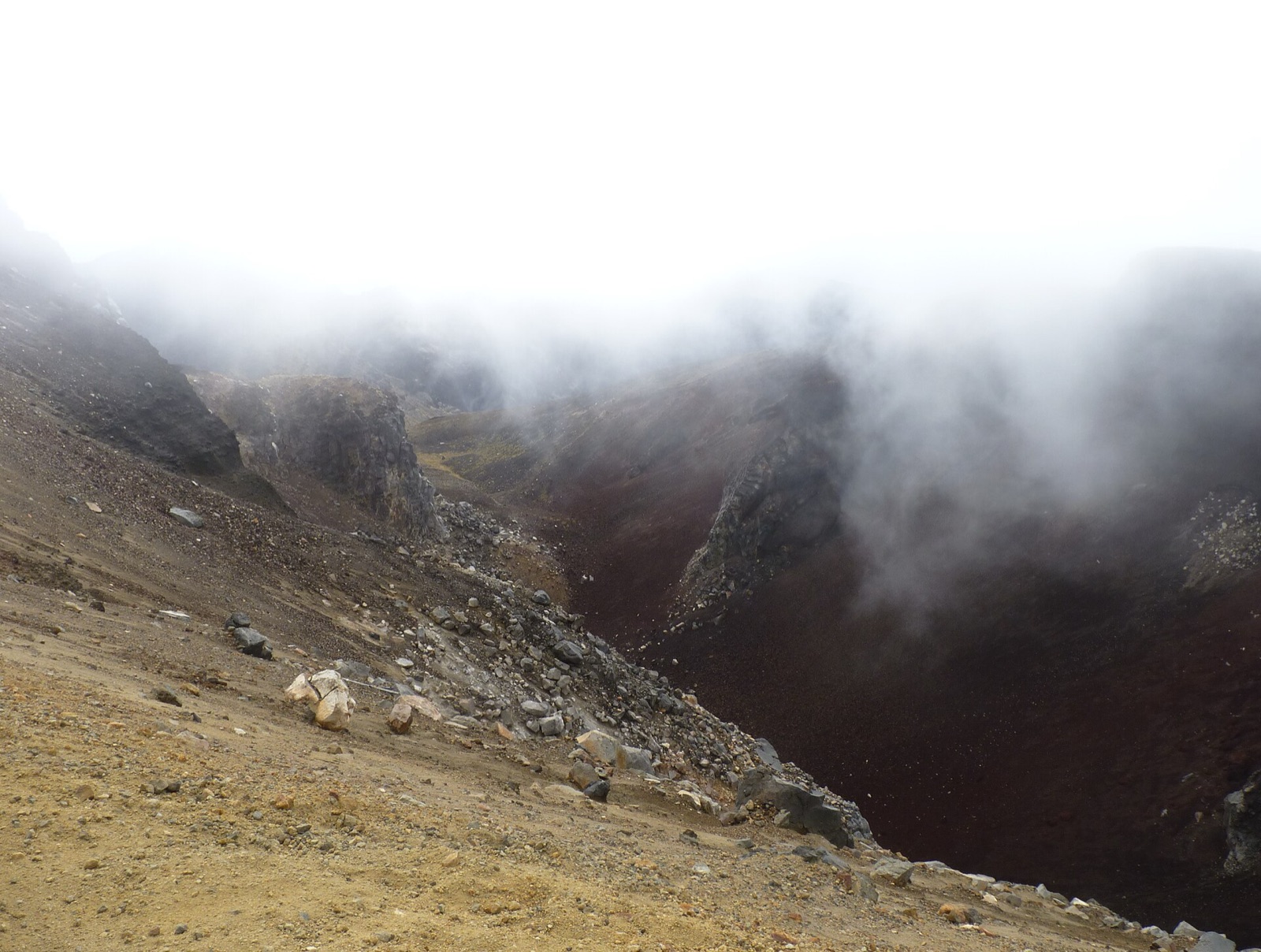 The dark red walls of Red Crater with cloud drifting through
